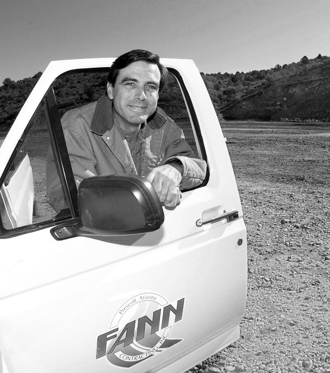 A man sitting in the driver's seat of a truck, representing Fann Contracting.