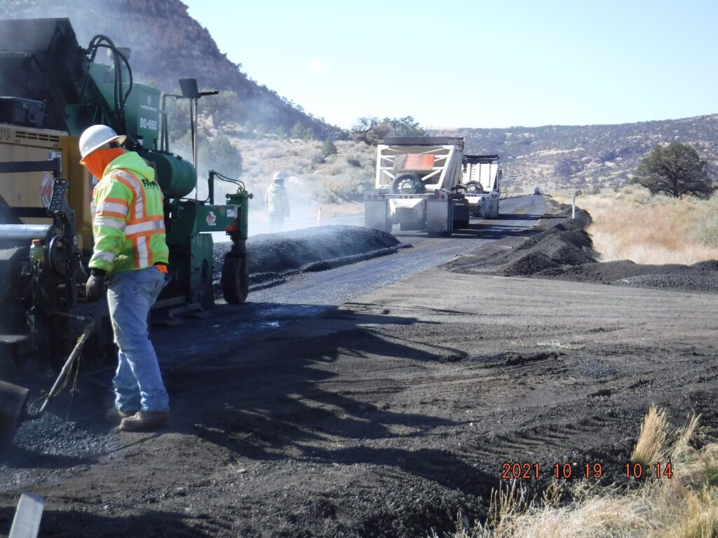 A worker is laying asphalt on US 160.