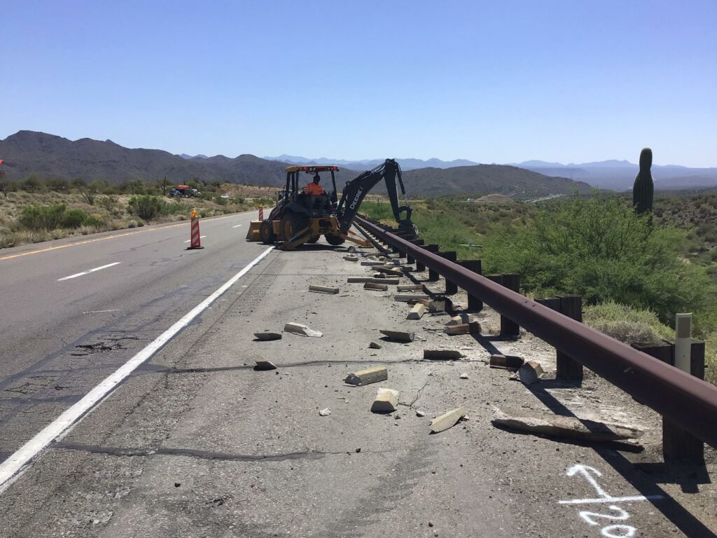 A construction crew is working on the side of a road.