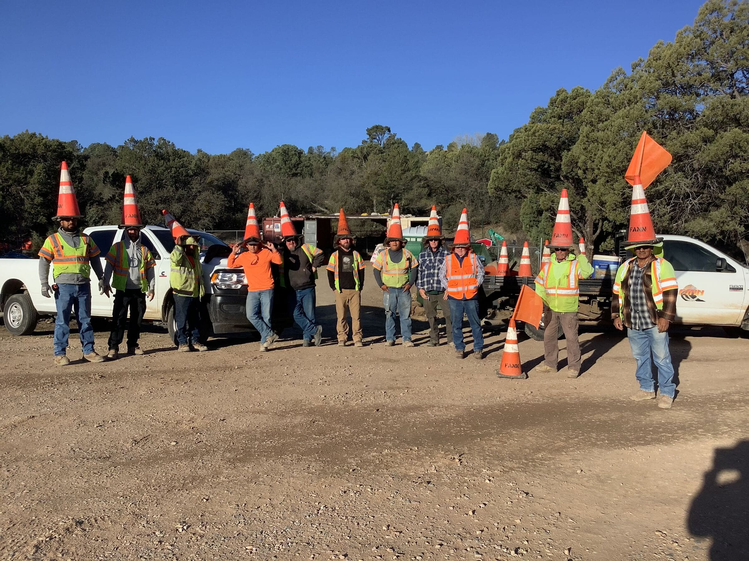 A group of construction workers holding orange cones.