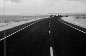 A black and white photo of an empty road by Fann Contracting.