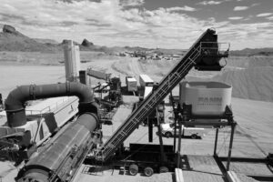 A black and white photo of a train in the desert, featuring Fann Contracting.