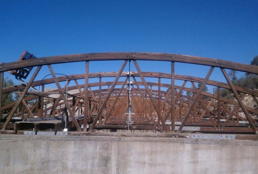 A wooden bridge is being built under a blue sky as part of the Old North Reservoir Replacement Project.