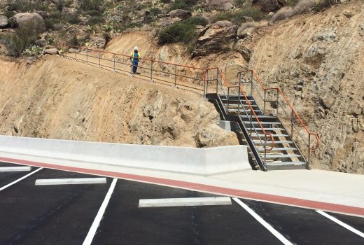 A parking lot near Yarnell Hill Memorial with stairs leading up to a cliff.