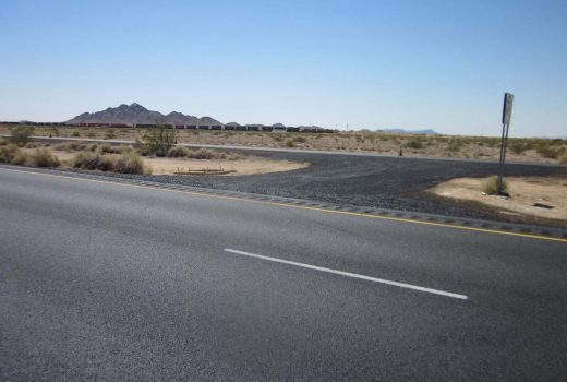 A road in the desert with a sign on Yuma - Casa Grande Hwy.