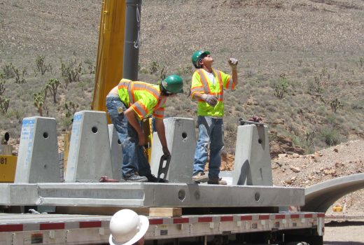 Two construction workers working on Diamond Bar Road Phase 2 bridge in the desert.