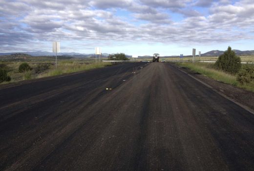A paved road in the middle of a field with a cloudy sky between Cordes Jct and Flagstaff Hwy.