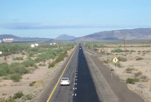 A car driving down Ehrenberg – Phoenix Hwy (I-10) in the desert.