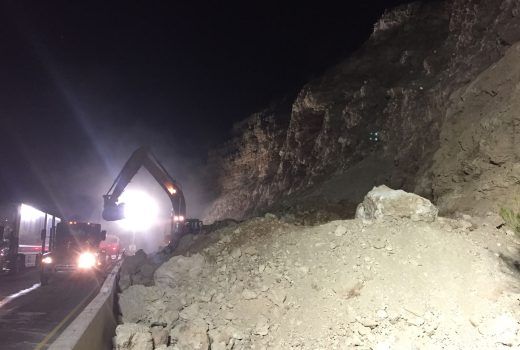 A truck is working on the side of a cliff during a rockfall on I-17 South of McGuireville at night.