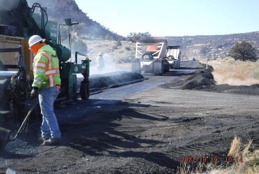 A worker is laying asphalt on US 160.