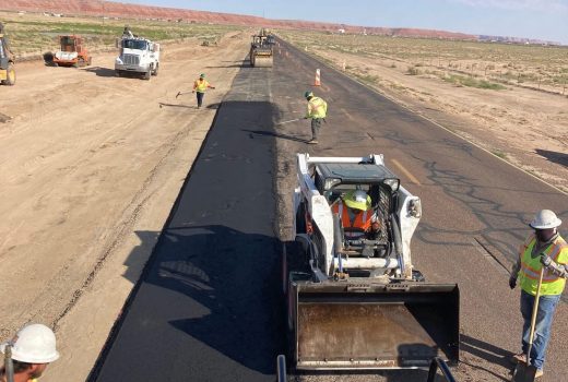 A group of workers are working on US 191 in the desert.