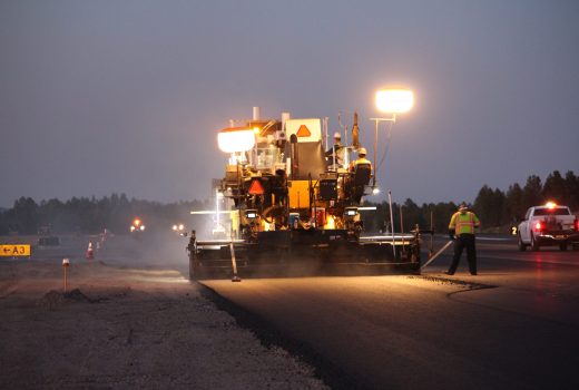 A machine is laying asphalt on a road.