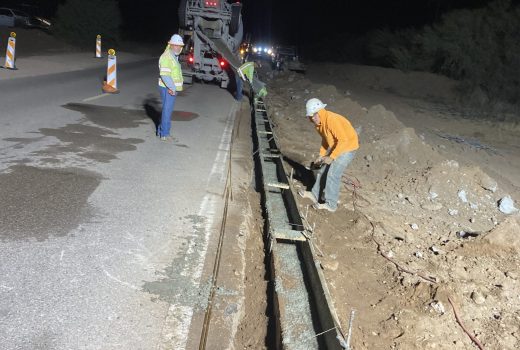 A group of workers are working on SR86 at night.